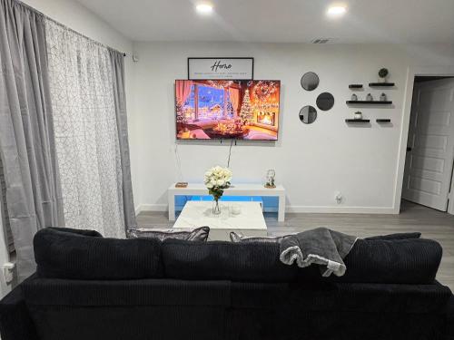 a living room with a black couch and a table at Family Home WITH 3 BR & 1RR in Grand Prairie