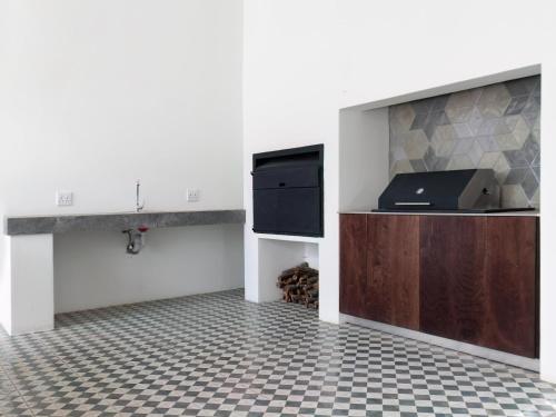 a kitchen with a counter and a sink and a tiled floor at The Tin Roof in Riebeek-Kasteel