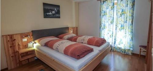 ein Bett mit zwei Kissen darauf in einem Zimmer in der Unterkunft Ferienwohnung Matzhof in Welschnofen