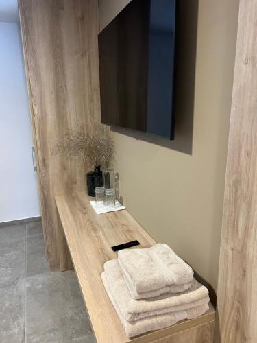 a wooden counter with towels and a television on a wall at Korantov Hram in Bukovci