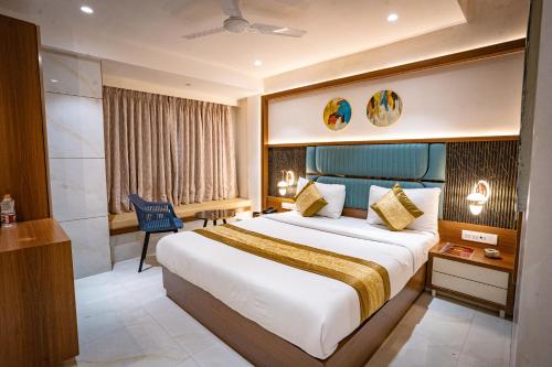 a hotel room with a large bed and a desk at Hotel Spencer-Navi Mumbai in Navi Mumbai
