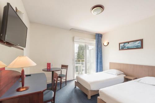 a hotel room with two beds and a window at Appart'City Classic Antibes in Antibes