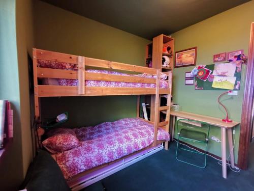 a bedroom with a bunk bed and a desk at Casa Verde in Sestriere