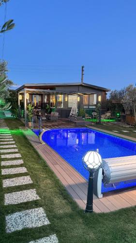 a swimming pool in front of a house at Akcavillagarden in İzmir