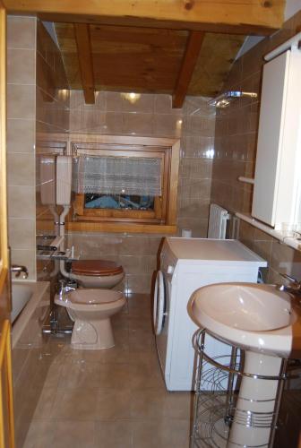 ein Badezimmer mit 2 WCs und einem Waschbecken in der Unterkunft Bait da Befin in Livigno