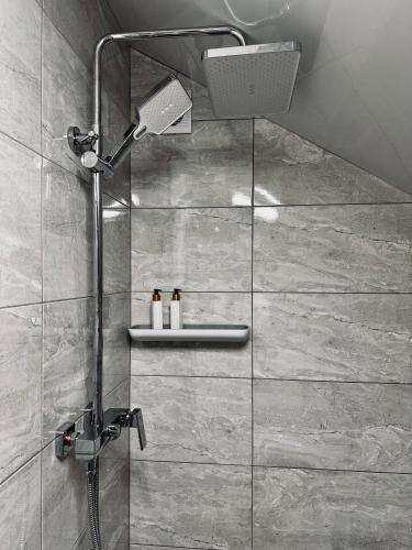 a shower with a shower head in a bathroom at Grey House in Slavske