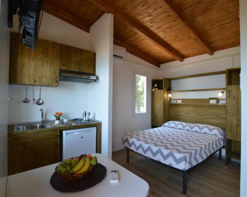a kitchen with a bed and a sink in a room at Settebello Village in Lido Di Fondi