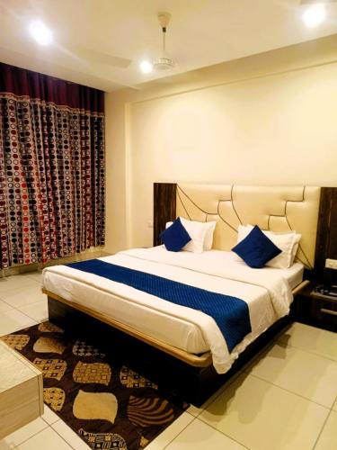 a bedroom with a large bed with blue pillows at Hotel President in Bharwain