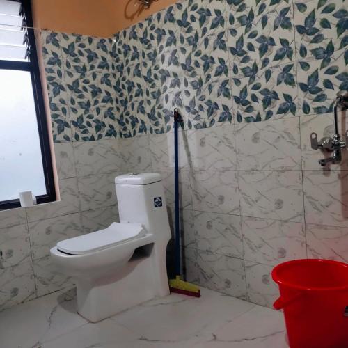 a bathroom with a white toilet in a room at Aurora Farmstay in Rongli