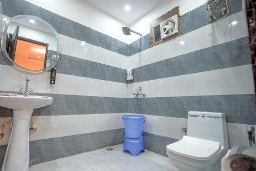 a bathroom with a sink and a toilet and a mirror at Hotel Stiltstay in Greater Noida