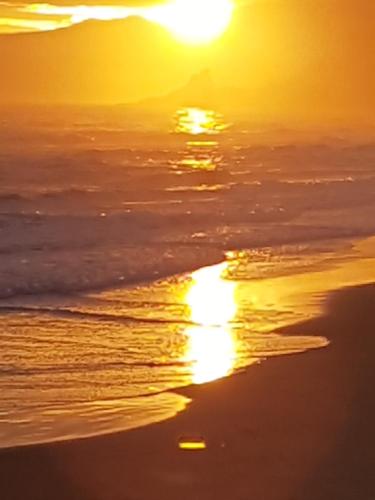 a sunset on a beach with the sun reflecting in the water at Hotel Club Torre Capovento in Sperlonga