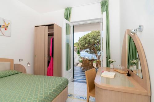 a bedroom with a bed and a desk and a table at Hotel Il Pino in Praiano
