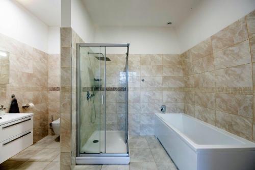 a bathroom with a shower and a tub and a toilet at Üveghuta Vendégház in Vágáshuta