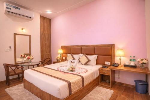a hotel room with a bed and a desk and a table at Hotel Stiltstay in Greater Noida