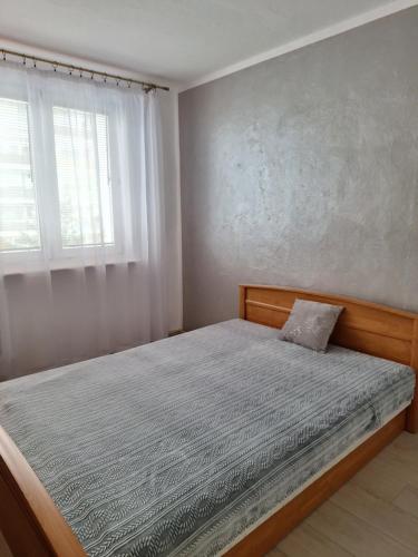 a bedroom with a bed and a window at Apartament Cichy Zakątek in Ruciane-Nida