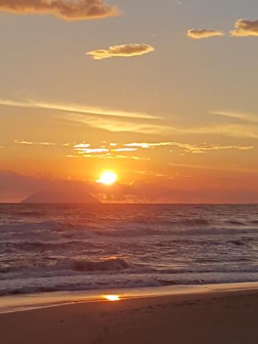a sunset on the beach with the ocean at Hotel Club Torre Capovento in Sperlonga