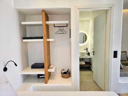 a bathroom with white walls and white shelves at myLithos Suites in Monolithos