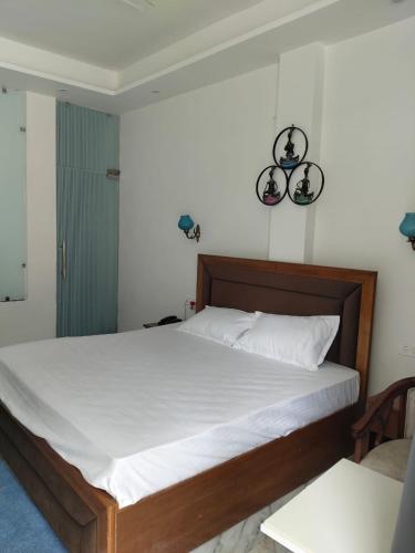 a bedroom with a large bed with white sheets at leisure valley resort in Jhājra
