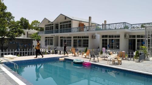 a house with a swimming pool in front of it at leisure valley resort in Jhājra