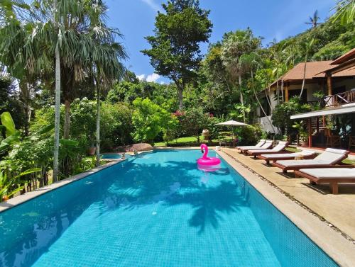 a swimming pool with a pink float in a resort at Private Balinese Bungalow for 2 - Shared pool - Lamai Koh Samui in Nathon Bay
