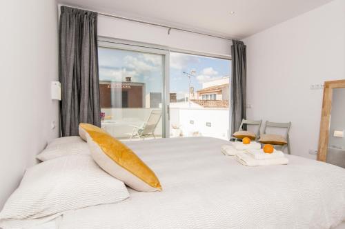 a bedroom with a white bed with a large window at Apartamento Sa Punta II in Portocolom