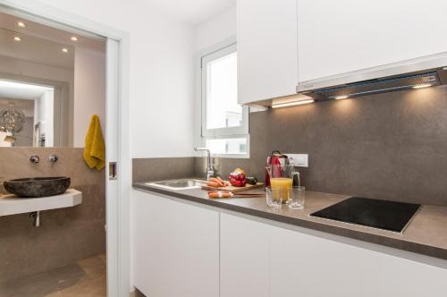 a kitchen with white cabinets and a counter top at Apartamento Sa Punta II in Portocolom