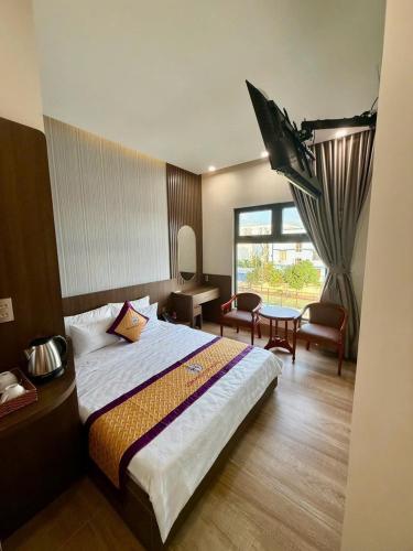 a hotel room with a bed and a desk and chair at Som Phu Quy 3 Hotel Phan Rang in Phan Rang–Tháp Chàm