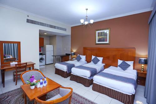 a hotel room with two beds and a table at Icon Hotel Apartments in Dubai