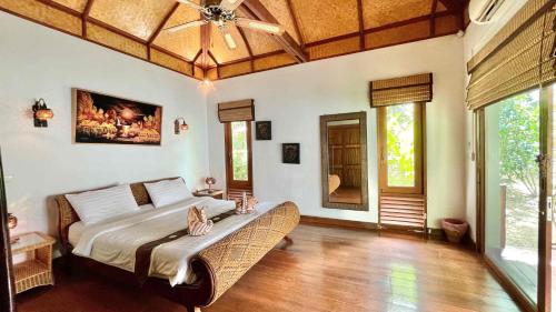 a bedroom with a bed and a ceiling fan at Private Balinese Bungalow for 2 - Shared pool - Lamai Koh Samui in Nathon Bay