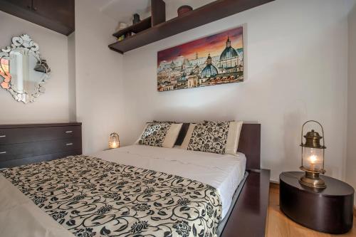 ローマにあるRome Candia Holiday Houseのベッドルーム1室(ベッド1台付)が備わります。壁に絵が飾られています。