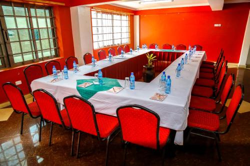a long table in a room with red chairs at Decasa Hotel in Nairobi