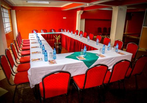 a long table in a room with red chairs at Decasa Hotel in Nairobi