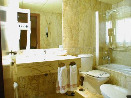 a bathroom with a toilet and a sink and a mirror at Hotel Estrella Norte in Isla