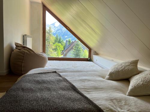 a bed in a room with a large window at Luxury Housing in Formigal in Formigal