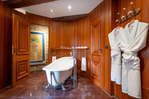 a bathroom with a tub and wooden walls at La Tour d'Enguerne in Montmeyan