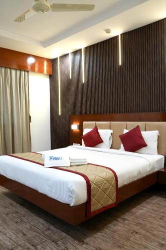 a bedroom with a large bed with red pillows at The Altruist Navi Mumbai Hotel in Navi Mumbai