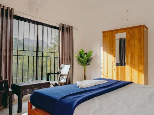 a bedroom with a bed and a large window at Lilliput Haven Homestay in Sultan Bathery