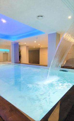 una grande piscina con una fontana d'acqua di Hotel Verdeneve a Opi