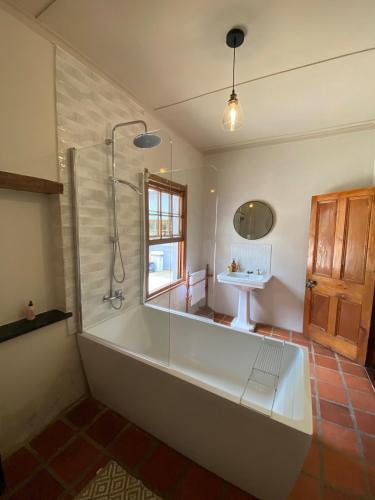 a bathroom with a large tub and a sink at Stoneygate Farm in Wakkerstroom