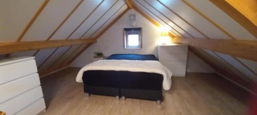 a bedroom with a large bed in a attic at Genieten in Wenduine in De Haan