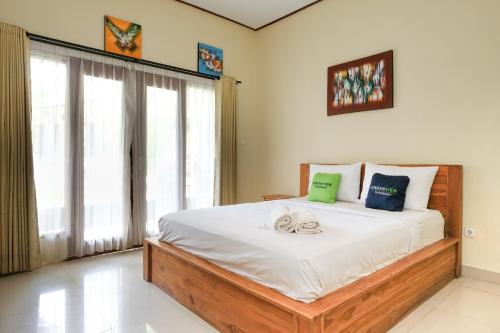 a bedroom with a large bed with towels on it at Lilis Cempaka Mas Guesthouse in Canggu