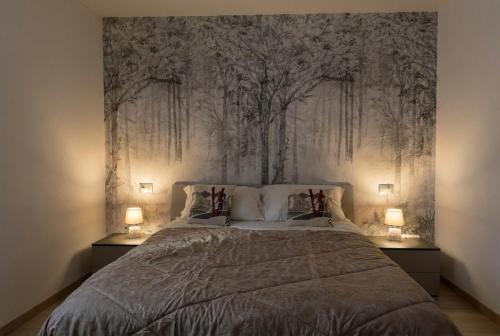a bedroom with a large bed with two lamps at Bormio365 Chalet in Valdisotto