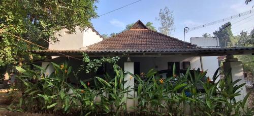 a small white house with a tiled roof at Athichans Homestay in Kuzhittura