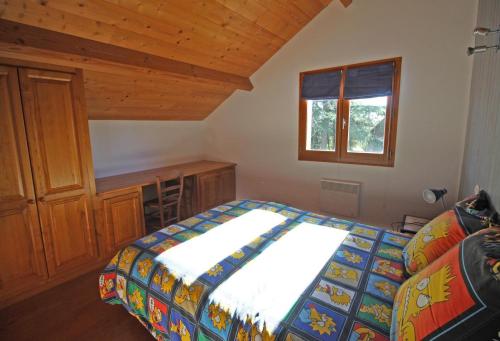 a bedroom with a bed and a desk and a window at Les tilleuls in Glanges