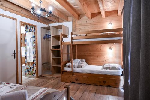 a bedroom with two bunk beds in a wooden room at Le chalet d'en ô in Les Clefs