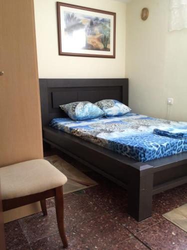 a bed in a room with a chair and a picture at Guest house Ashdod-beach in Ashdod