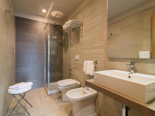 a bathroom with a sink and a toilet and a shower at President Park Hotel in Acitrezza