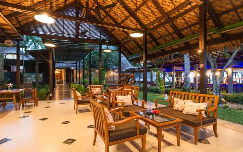an outdoor patio with tables and chairs and a table at Islanda Hideaway Resort in Krabi