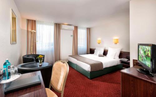 a hotel room with a bed and a television at Best Western Hotel zur Post in Bremen