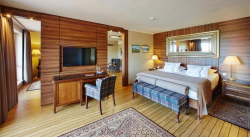 ein Hotelzimmer mit einem Bett und einem TV in der Unterkunft Kormoran Medispa in Rowy